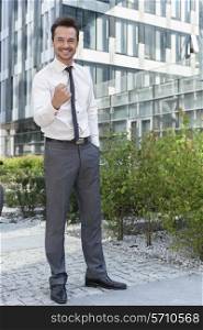 Full length portrait of successful businessman outside office building