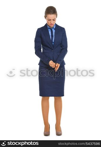 Full length portrait of thoughtful business woman adjusting cuff