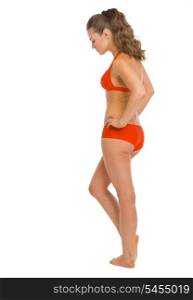 Full length portrait of thoughtful young woman in swimsuit . rear view