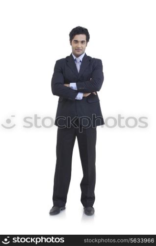 Full length portrait of young businessman with arms crossed isolated over white background