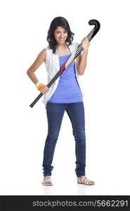 Full length portrait of young female in casual wear holding hockey stick over white background
