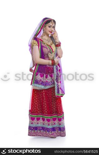 Full length portrait of young Indian bride over white background