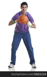 Full length portrait of young man holding basketball over white background
