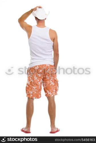 Full length portrait of young man in shorts and hat. rear view