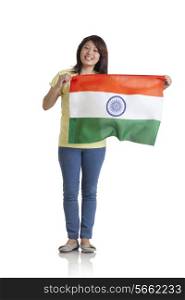 Full length portrait of young woman in casuals holding Indian flag over white background