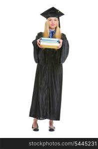 Full length portrait of young woman in graduation gown giving books