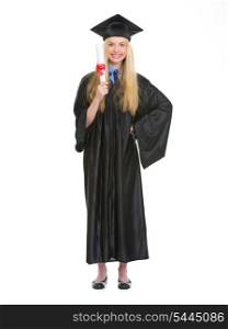 Full length portrait of young woman in graduation gown showing diploma