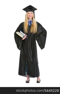 Full length portrait of young woman in graduation gown with books
