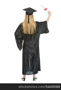 Full length portrait of young woman in graduation gown with diploma . rear view