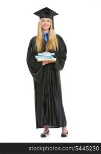 Full length portrait of young woman in graduation gown with stack of books