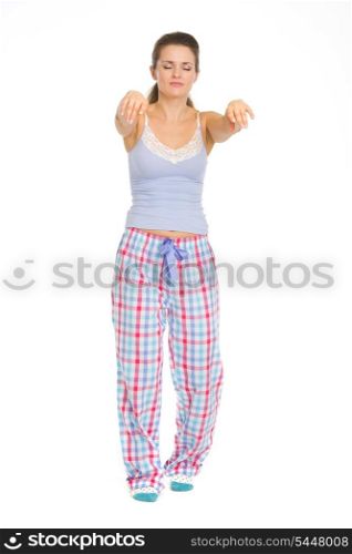 Full length portrait of young woman in pajamas sleep walking