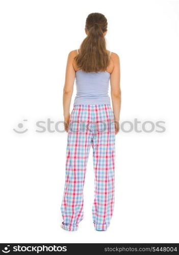 Full length portrait of young woman in pajamass. Rear view