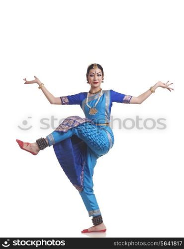 Full length portrait of young woman performing Bharatanatyam over white background