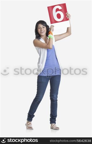 Full length portrait of young woman signaling a six over white background