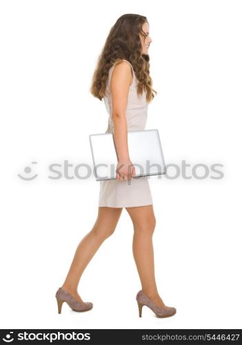 Full length portrait of young woman with laptop going sideways