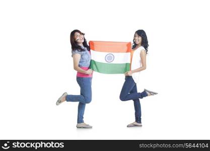 Full length portrait of young women in casuals holding Indian flag over white background