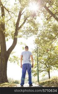 Full length rear view of fit man standing on path in park