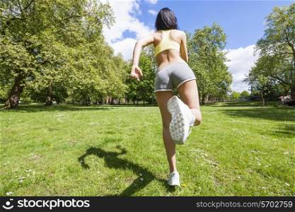 Full length rear view of fit woman jogging at park