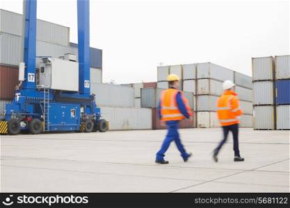 Full-length rear view of workers walking in shipping yard