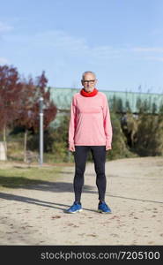 Full length Runner in rose sportswear standing at the park