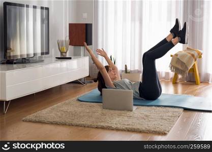 Full length shot of a woman doing exercise at home