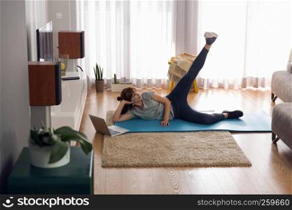 Full length shot of a woman doing exercise at home