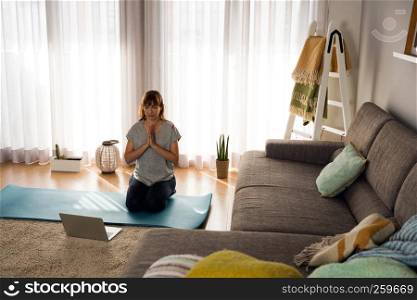 Full length shot of a woman doing yoga at home