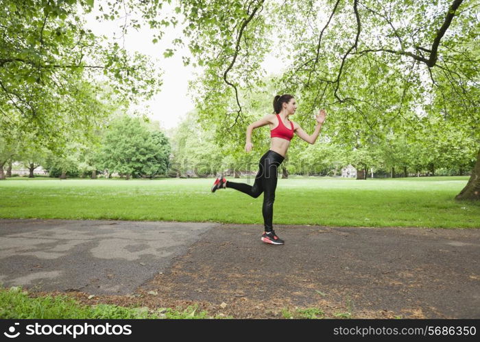 Full length side view of fit woman jogging in park