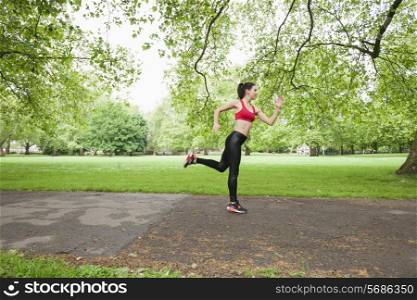 Full length side view of fit woman jogging in park