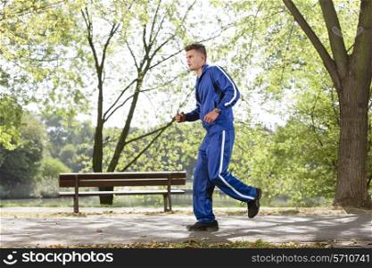 Full length side view of man jogging on path in park