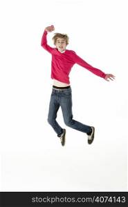 Full Length Studio Portrait Of Jumping Teenage Boy