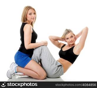 Full length two women doing stretching fitness exercise isolated on white background