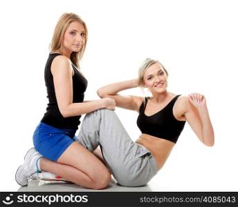 Full length two women doing stretching fitness exercise isolated on white background