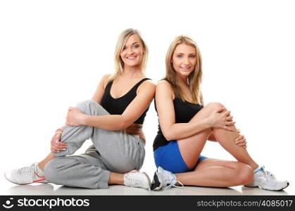 Full length two young sporty women after intense workout, isolated on white background.