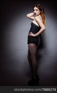 Full length woman straight long hair make-up posing in studio dark background