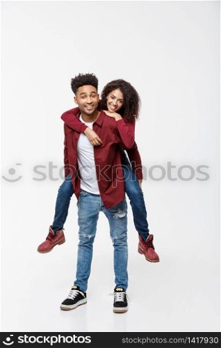 Full length young attractive african american lady riding back on her boyfriend back and enjoy playing to each other. Full length young attractive african american lady riding back on her boyfriend back and enjoy playing to each other.