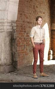 Full length young handsome man fashion model casual style posing on street of old town Gdansk Poland Europe
