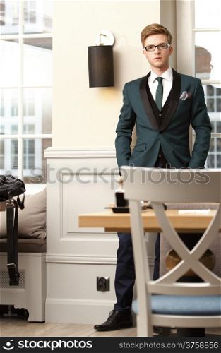 Full length young handsome stylish man fashion model posing in trendy cafe /restaurant
