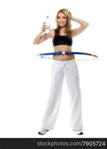 Full length young sporty girl doing exercise with hula hoop drinking water. Fitness woman isolated on white