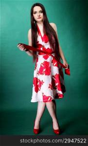 Full length young woman in summer flowery dress on green background fashion photo