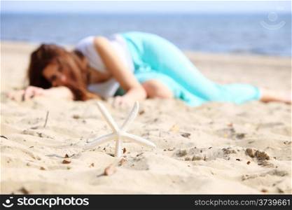 Full length young woman on seacoast with starfish on sand - summer vacation