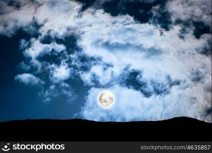 Full moon above mountain at dark blue night sky with stars