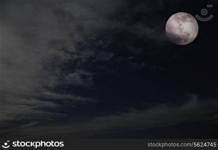 Full moon in night sky with clouds.