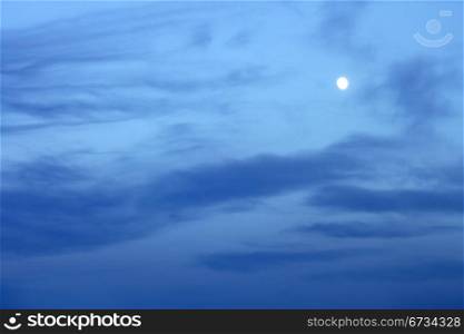 Full moon in the bluish evening clouds