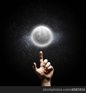 Full moon. Man&rsquo;s hand pointing at moon with finger