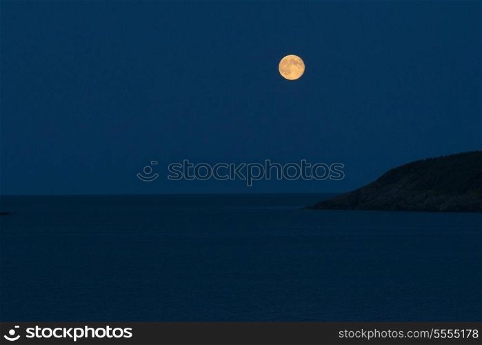 Full moon over the ocean at night, Calvert, Avalon Peninsula, Newfoundland And Labrador, Canada