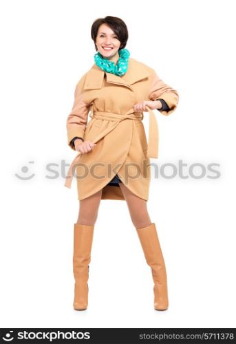 Full portrait of happy woman in beige autumn coat and leather boot with green scarf standing isolated on white background