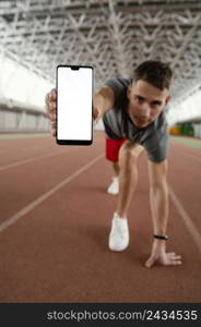 full shot athlete holding smartphone