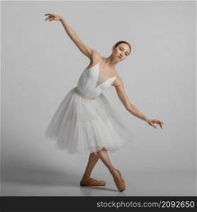 full shot ballerina posing with pointe shoes