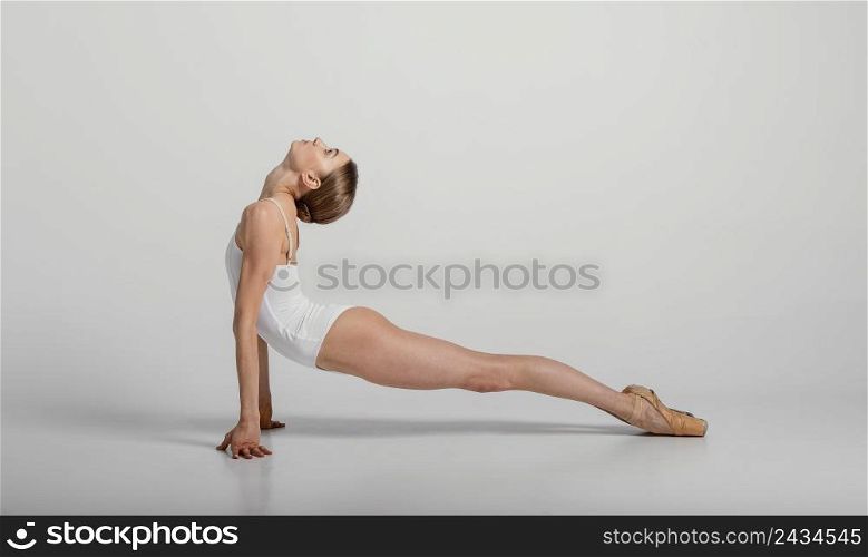 full shot ballerina stretching her back